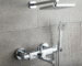 A polished chrome thermostatic shower system with a rain showerhead and handheld sprayer, essential for hotel safety and comfort.